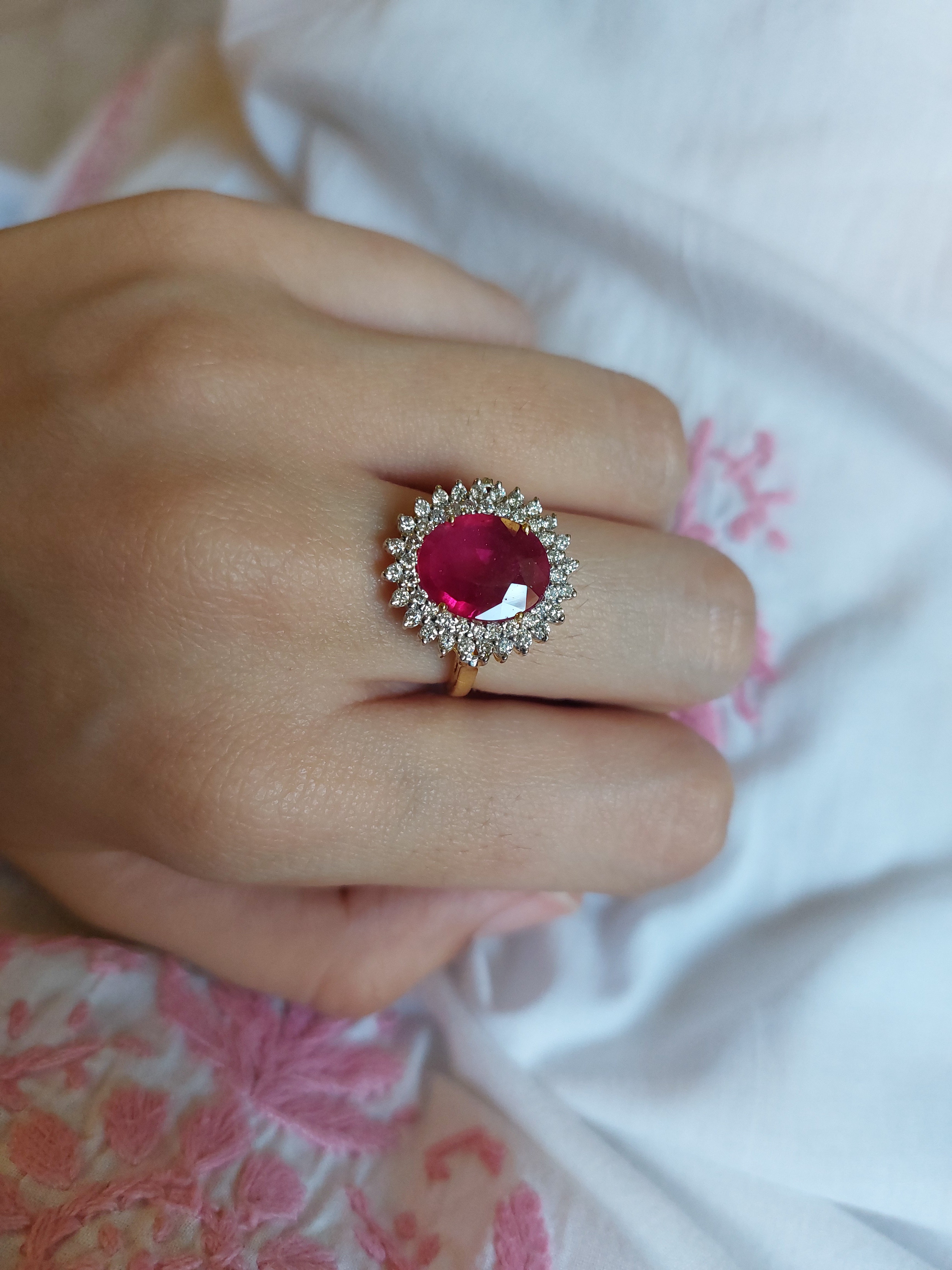 14K gold ruby ring with diamond halo on hand