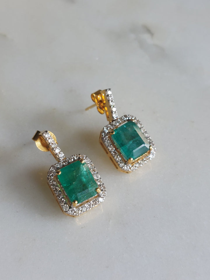 14K gold square emerald earrings on marble surface