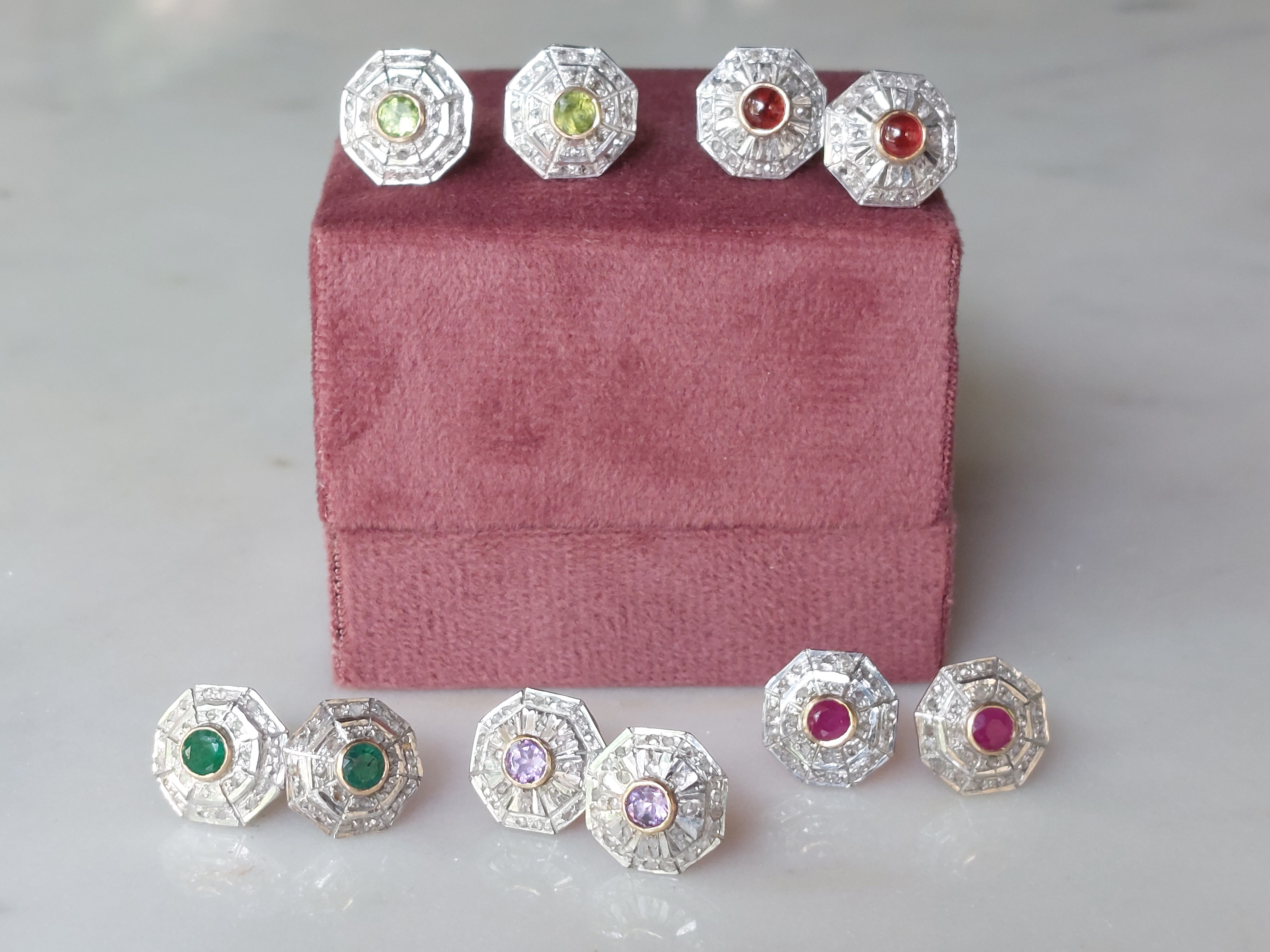 Art Deco earrings with green red and purple gemstones on velvet stand
