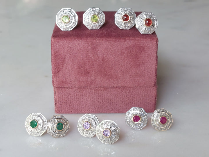 Art Deco earrings with green red and purple gemstones on velvet stand