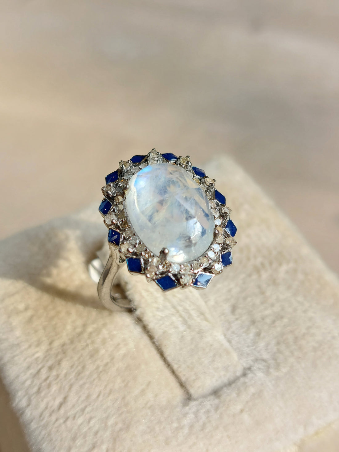 Moonstone and diamond halo ring close-up on model