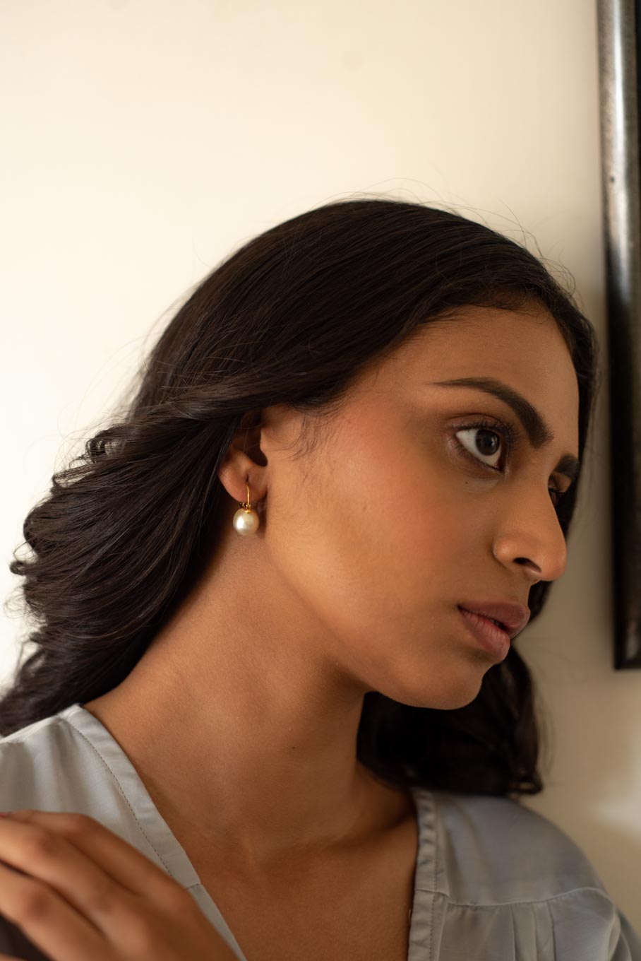 14K gold pearl drop earrings worn with light blue blouse