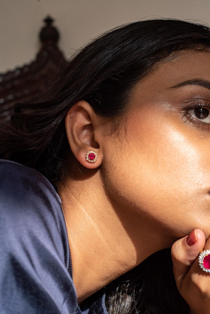 14K gold ruby stud earring worn on ear with matching ring