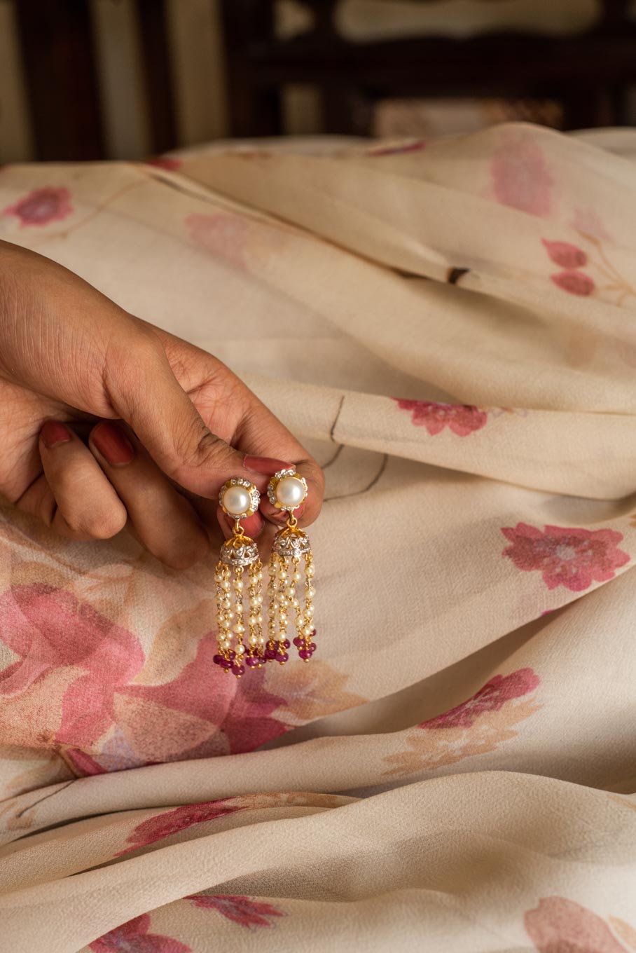 14K gold Nabila Jhumkas pearl chains on floral fabric