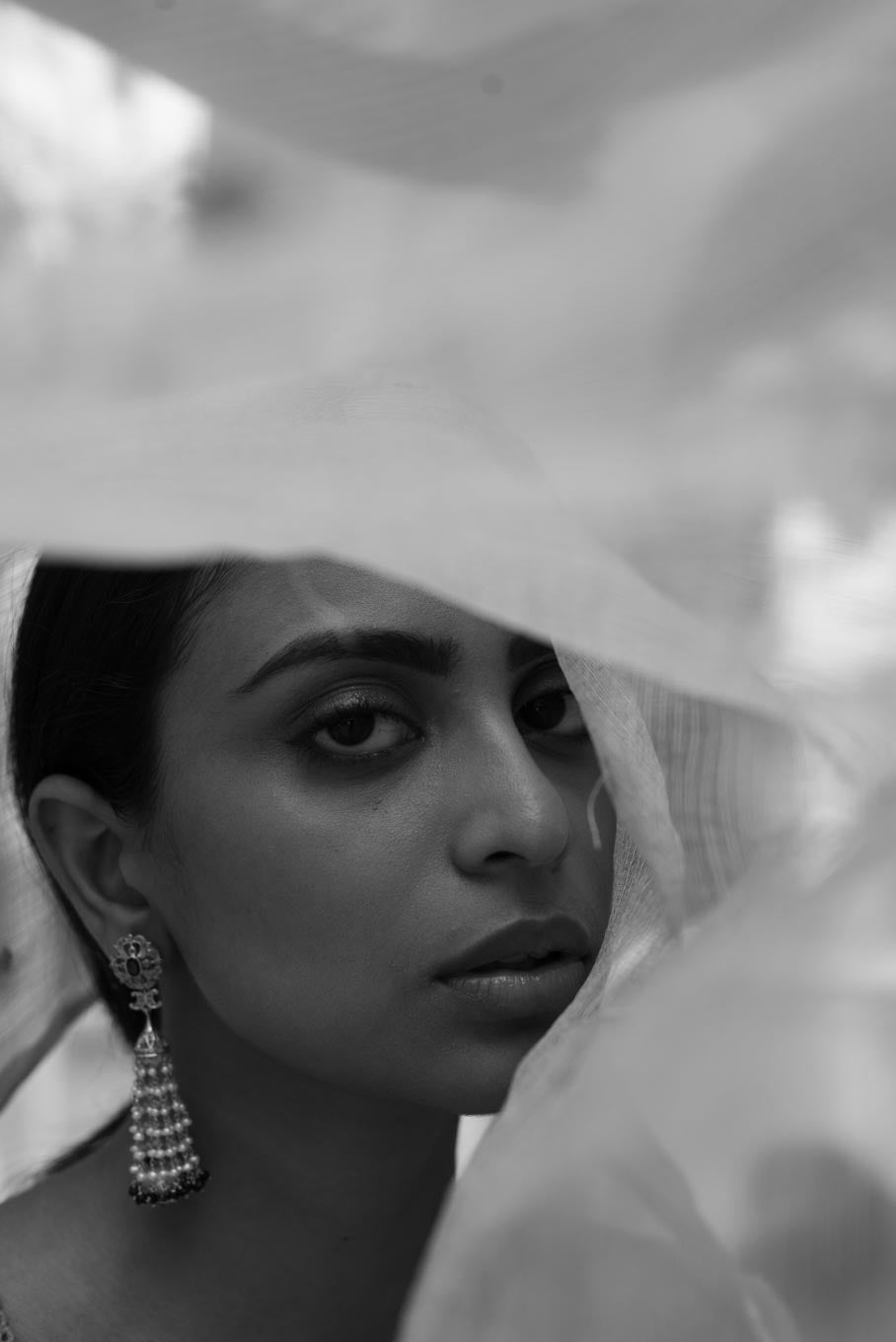 Multi-tiered silver jhumka earrings worn by model