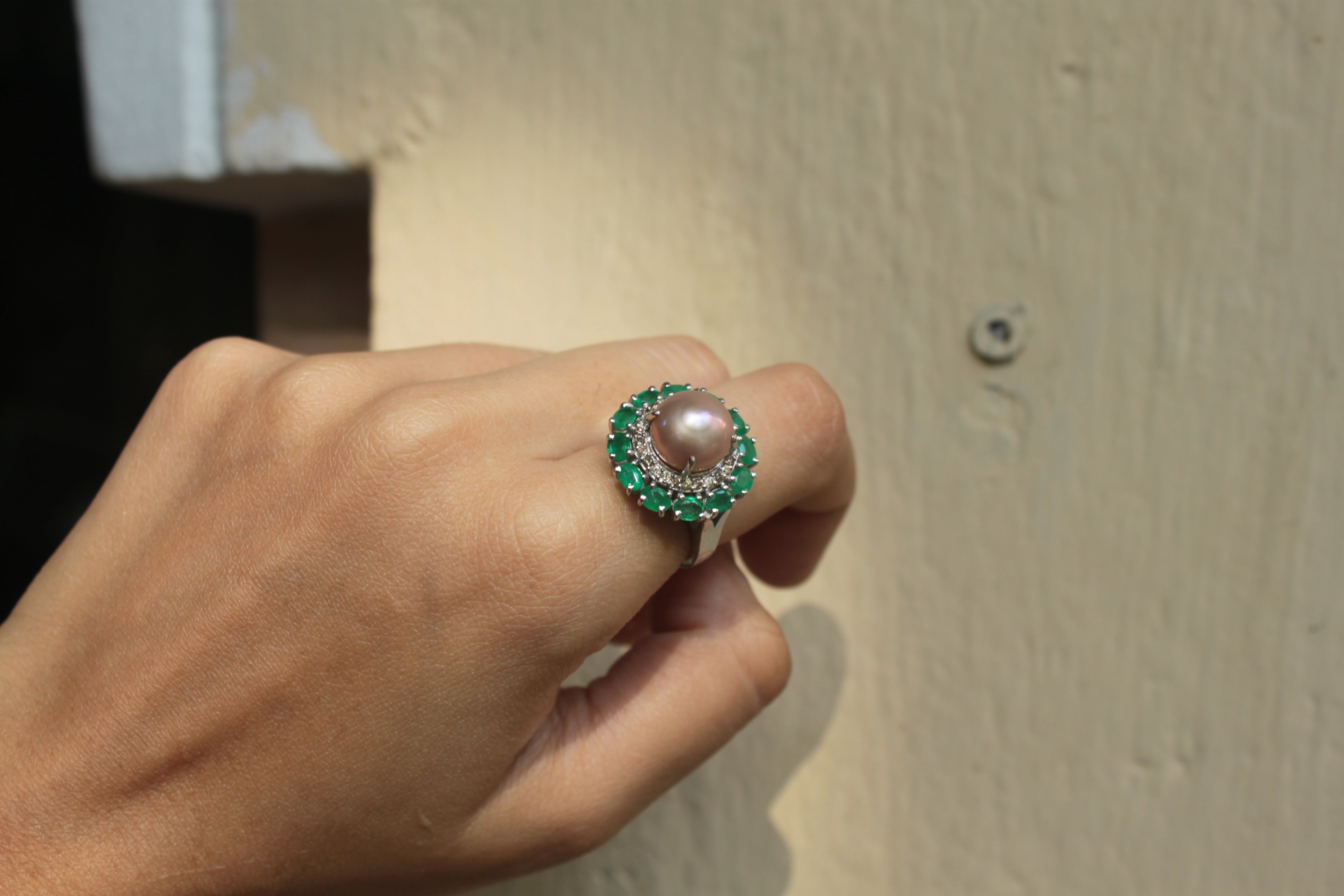925 silver pearl ring with green gemstones on beige background