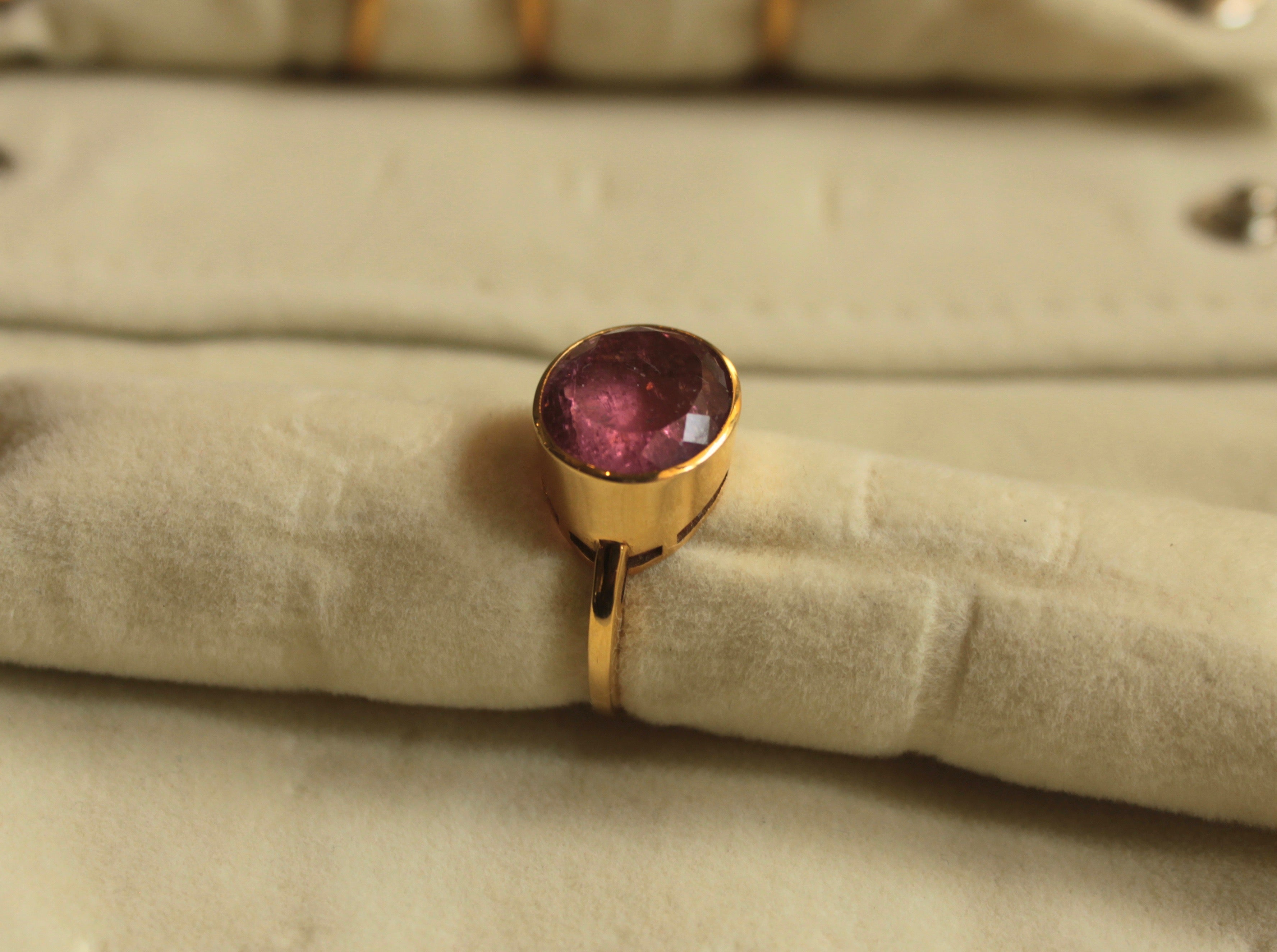 14K gold tourmaline ring with bezel-set round pink gemstone close-up